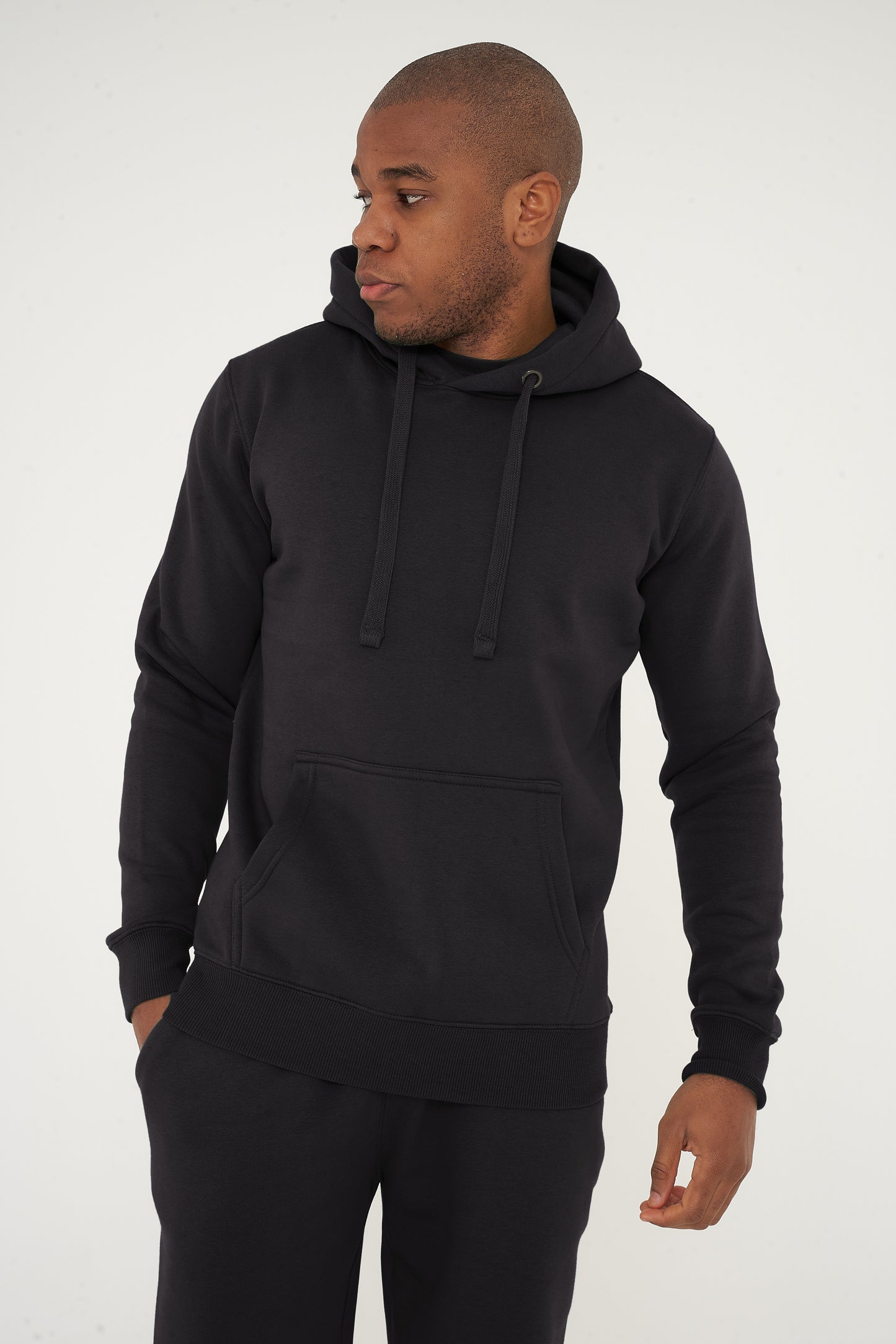 Male model standing in black 365 Regular Hoodie and shorts, hands relaxed – regular fit, 365 Collection.
