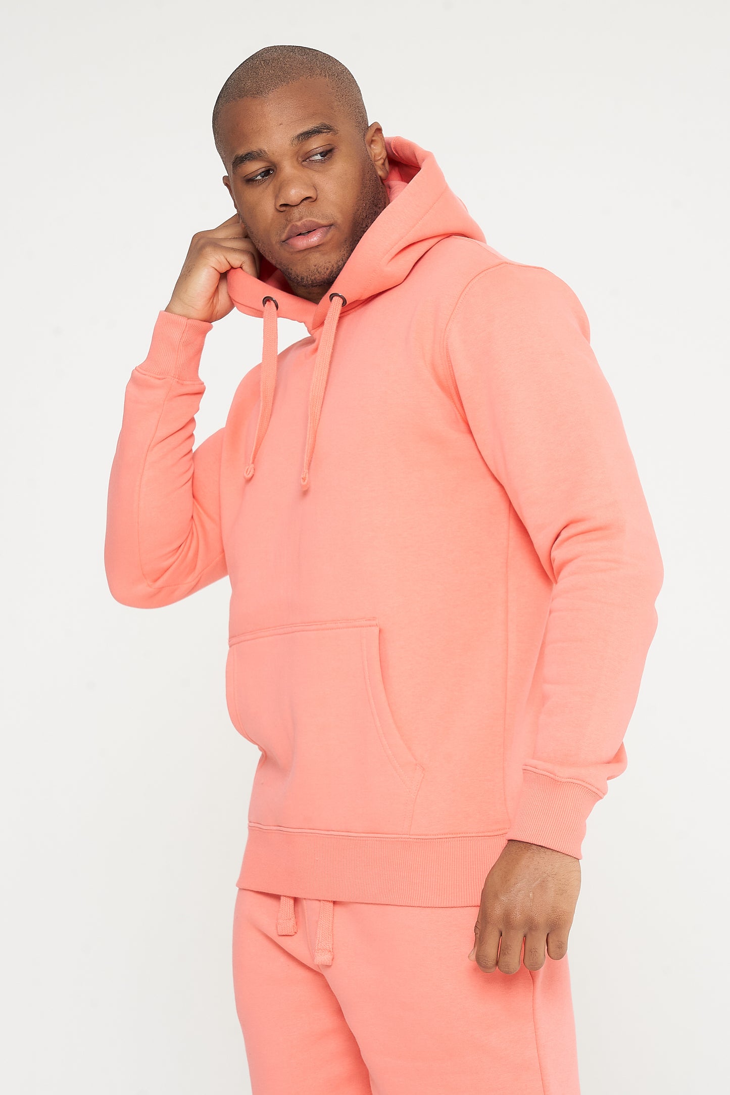 Male model side angle adjusting hood of coral 365 Regular Hoodie and shorts – regular fit, 365 Collection.