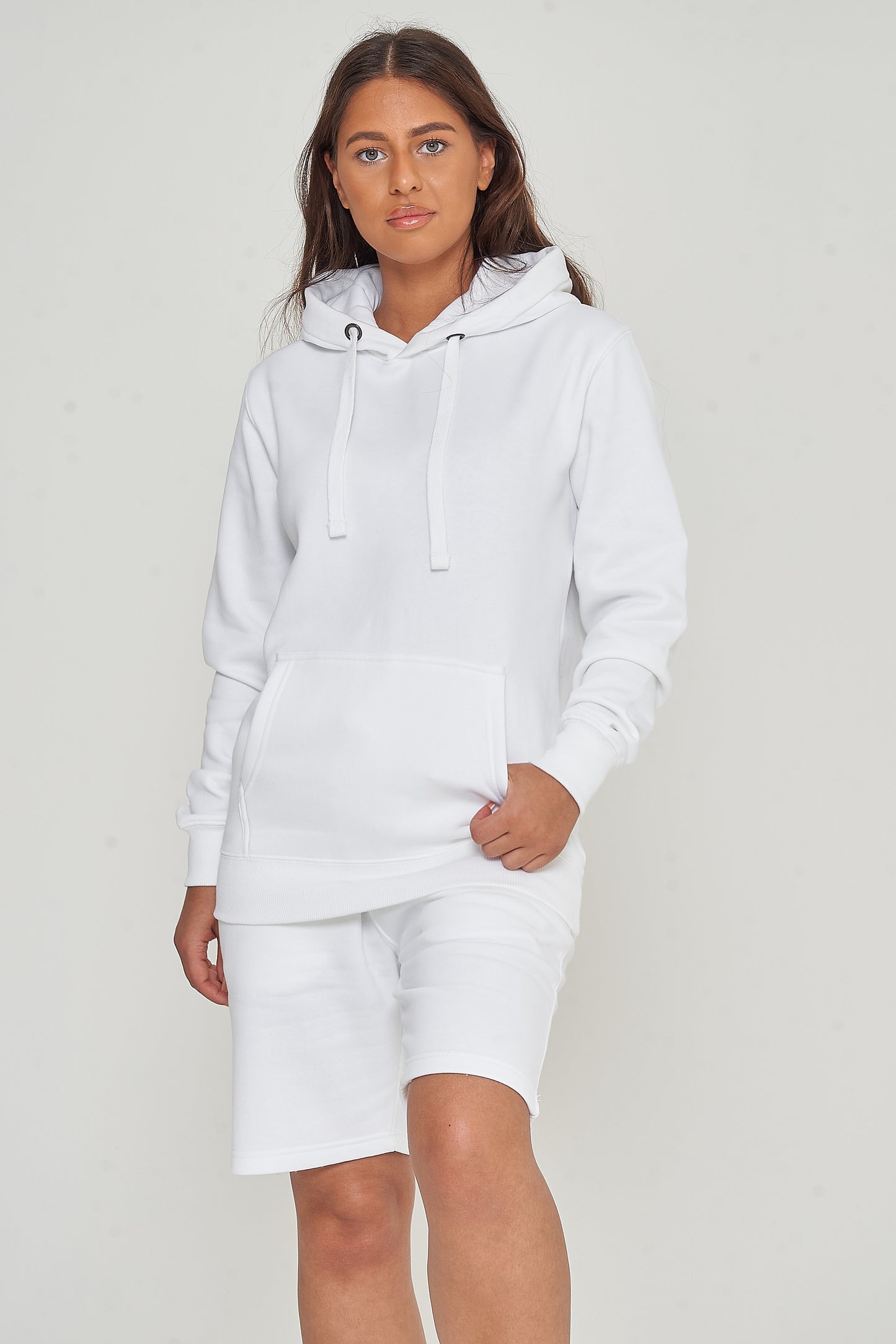 A woman wearing a basic white hoodie with casual shorts, front-facing.