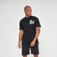 Male model front view wearing black Fallen Angel T-shirt with RV graphic, paired with black shorts – regular fit, Greek Mythology collection.