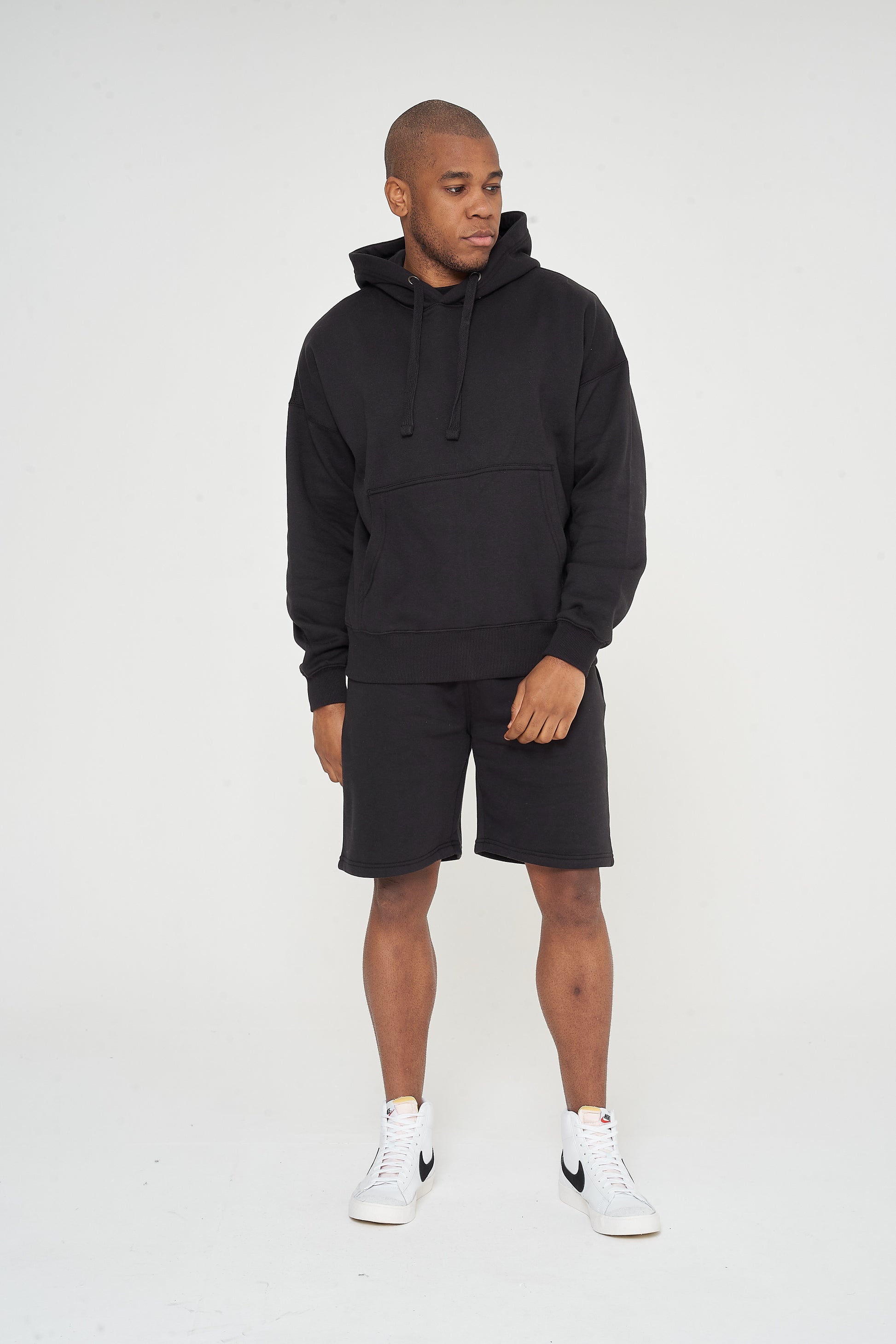 Male model front view wearing black 365 Oversized Hoodie and black shorts – oversized fit, 365 Collection.