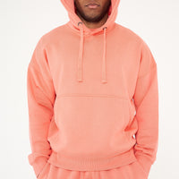 Male model full-body shot in coral 365 Oversized Hoodie and shorts, styled with white sneakers – 365 Collection – oversized fit.