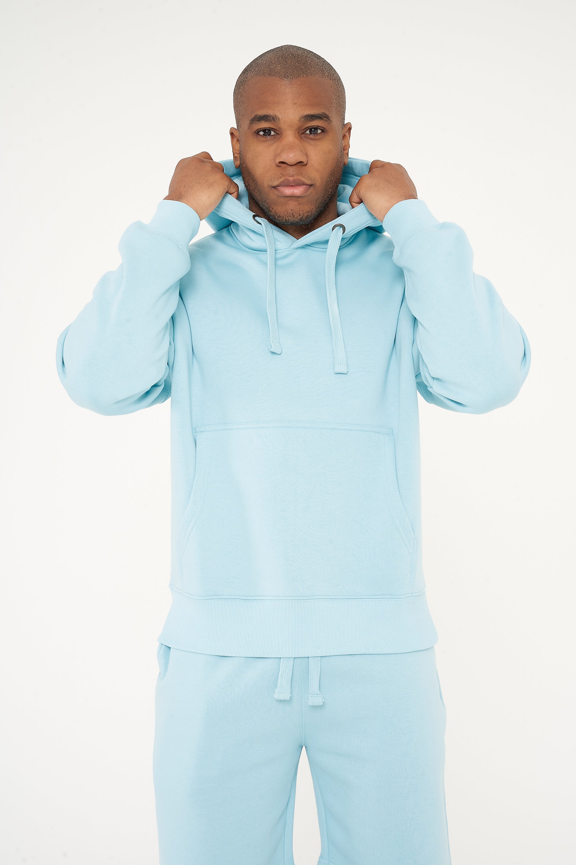 Model adjusting hood in turquoise oversized hoodie - 365 Collection.