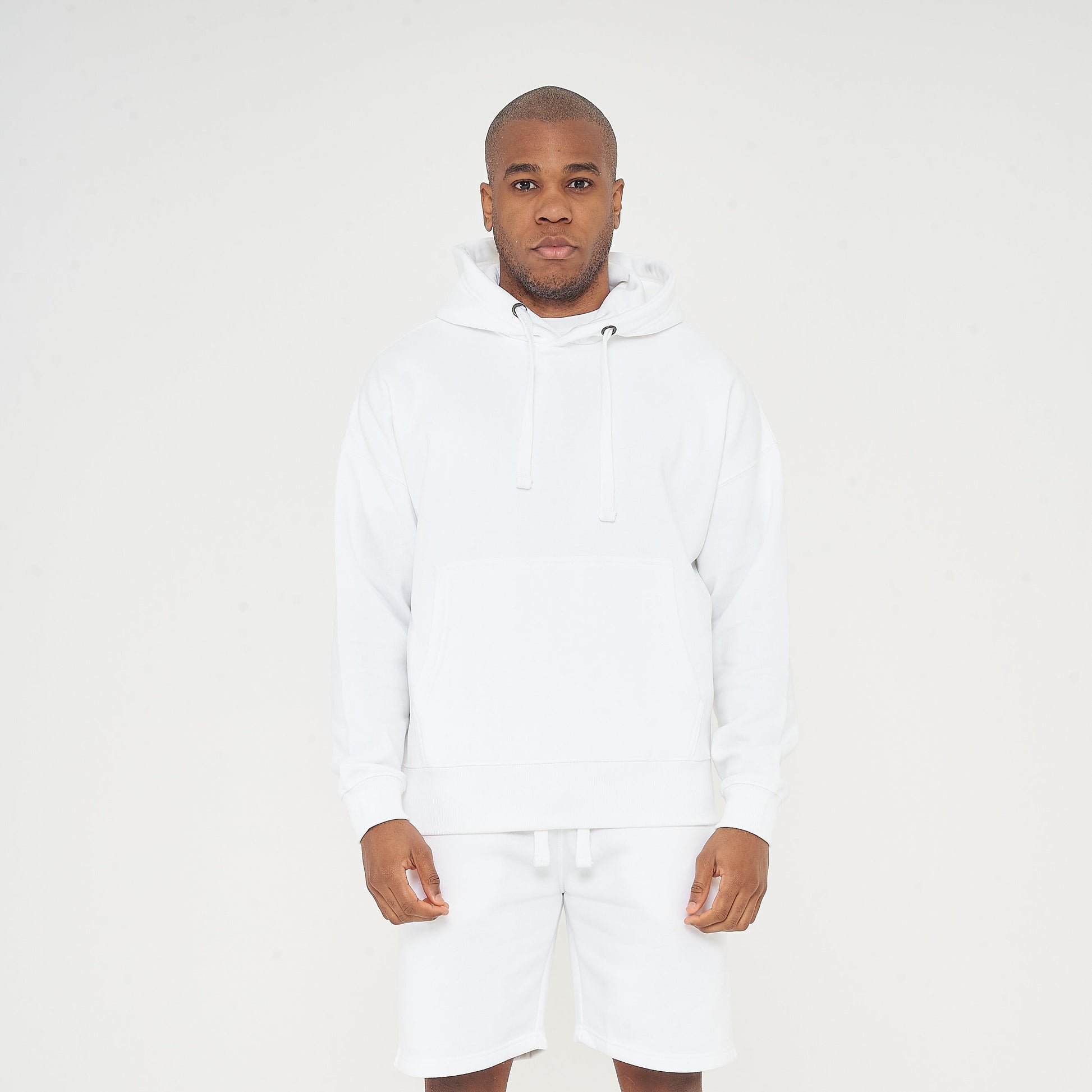 Full-body front view of model wearing men's white oversized hoodie, 365 Collection.