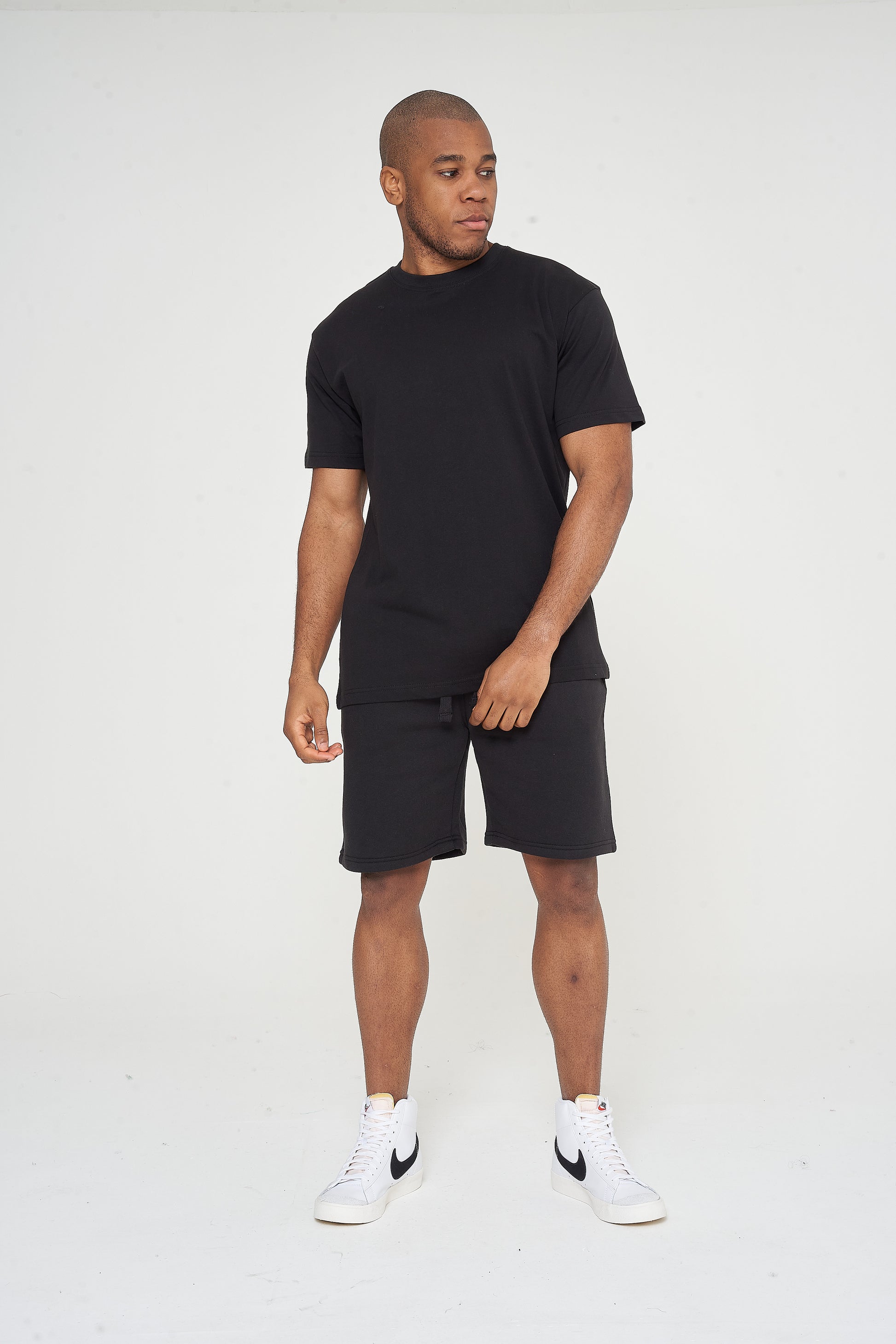 Male model front view wearing a black 365 Oversized T-shirt and black shorts – oversized fit, 365 Collection.