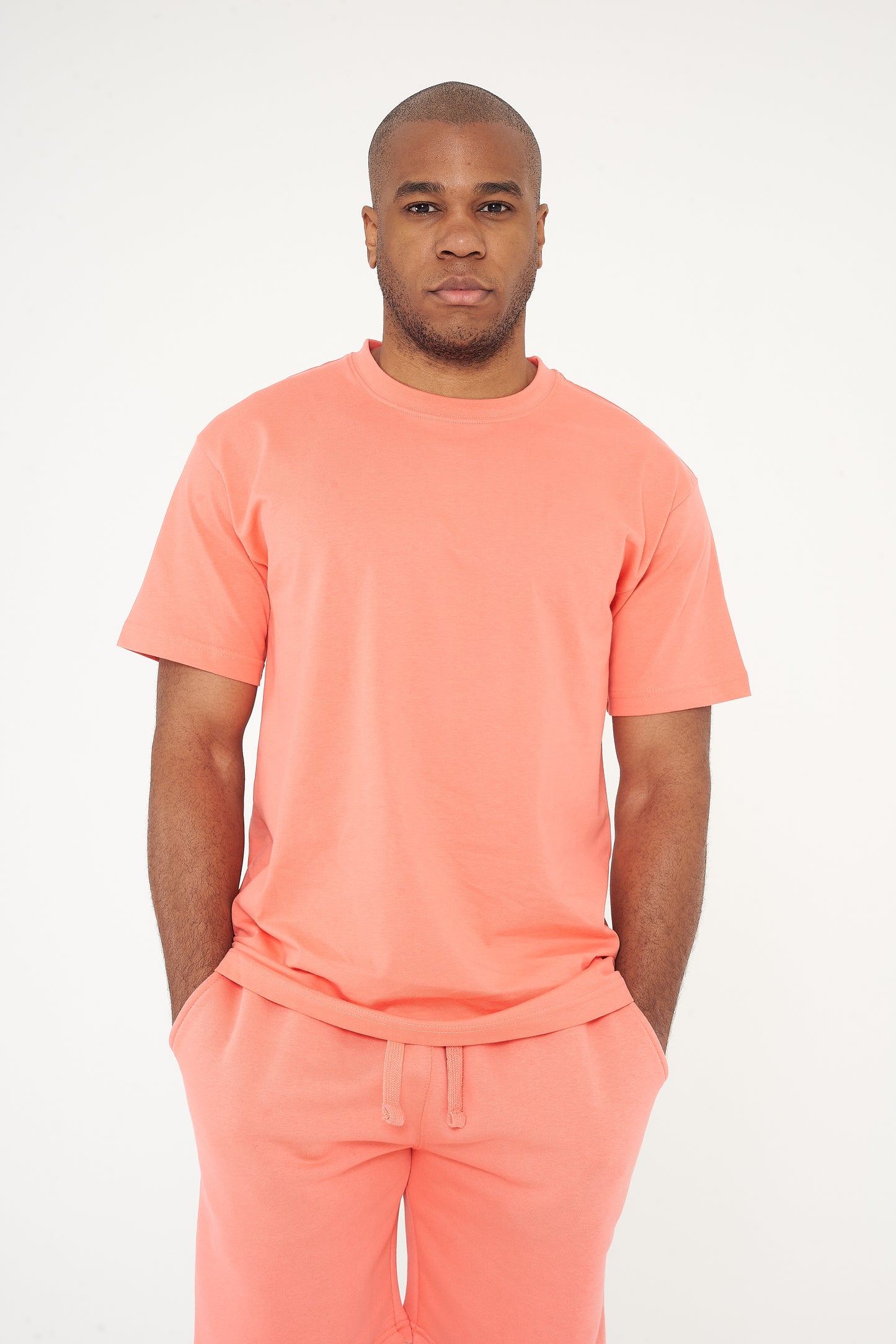 Male model standing in coral 365 Oversized T-shirt and shorts, relaxed posture – 365 Collection – oversized fit.