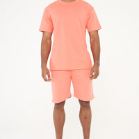 Male model full-body shot in coral 365 Oversized T-shirt and shorts, white sneakers – 365 Collection – oversized fit.