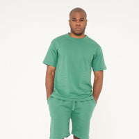 Full-body view of male model wearing green oversized T-shirt and matching shorts - 365 Collection.