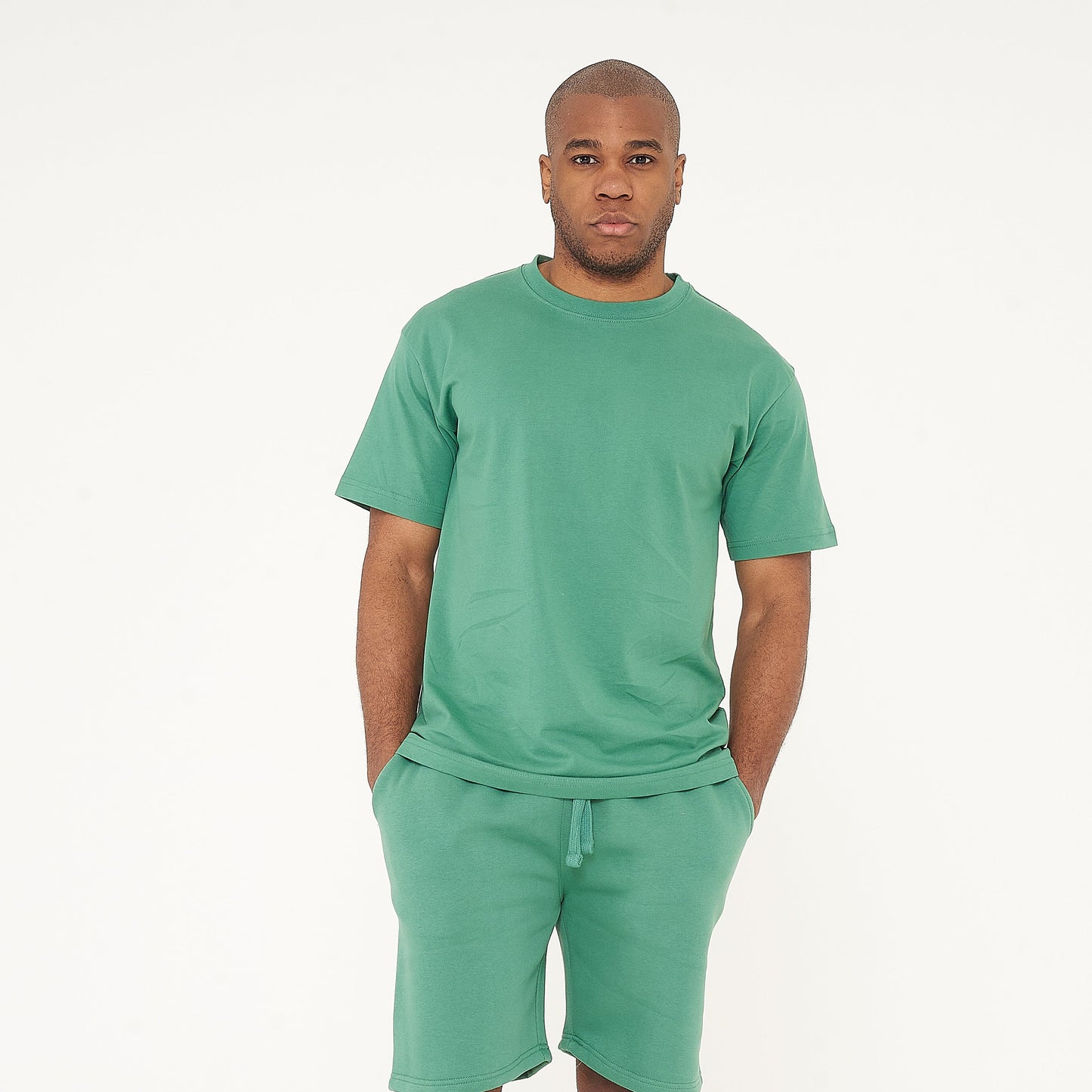 Full-body view of male model wearing green oversized T-shirt and matching shorts - 365 Collection.