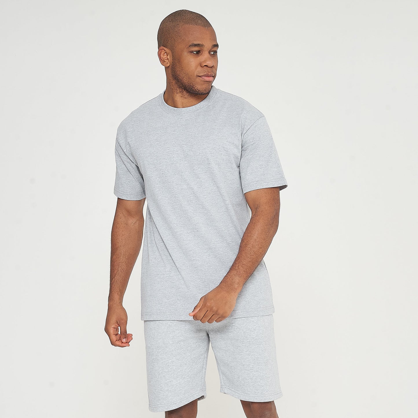 Front-facing model in grey oversized T-shirt with one hand in pocket - 365 Collection.