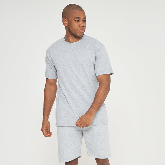Front-facing model in grey oversized T-shirt with one hand in pocket - 365 Collection.