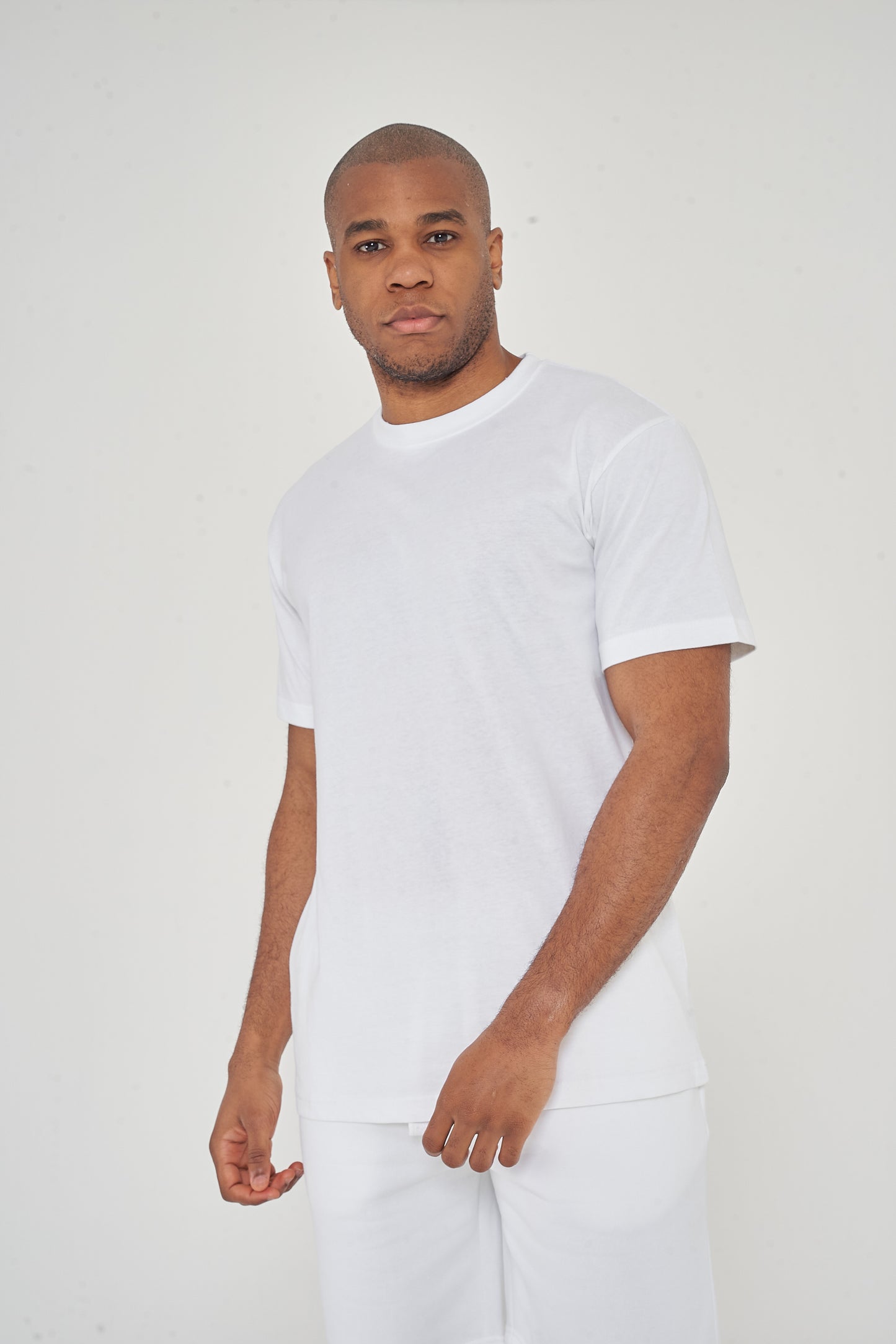 Upper body view of model wearing men's white oversized T-shirt, head to waist, 365 Collection.