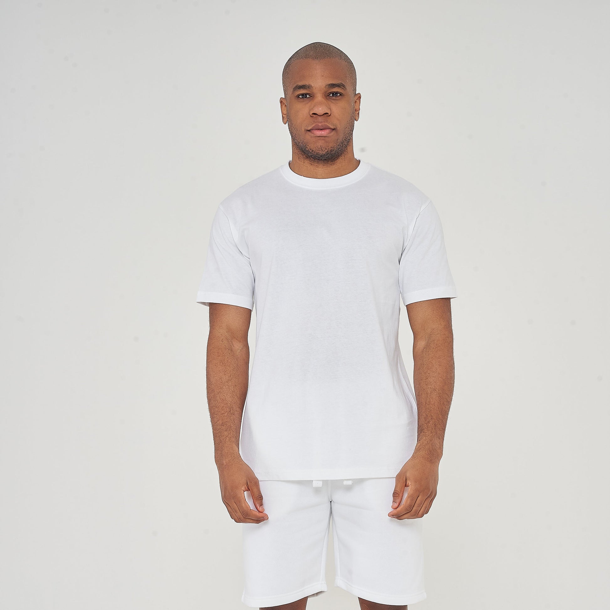 Full-body front view of model wearing men's white oversized T-shirt, 365 Collection.