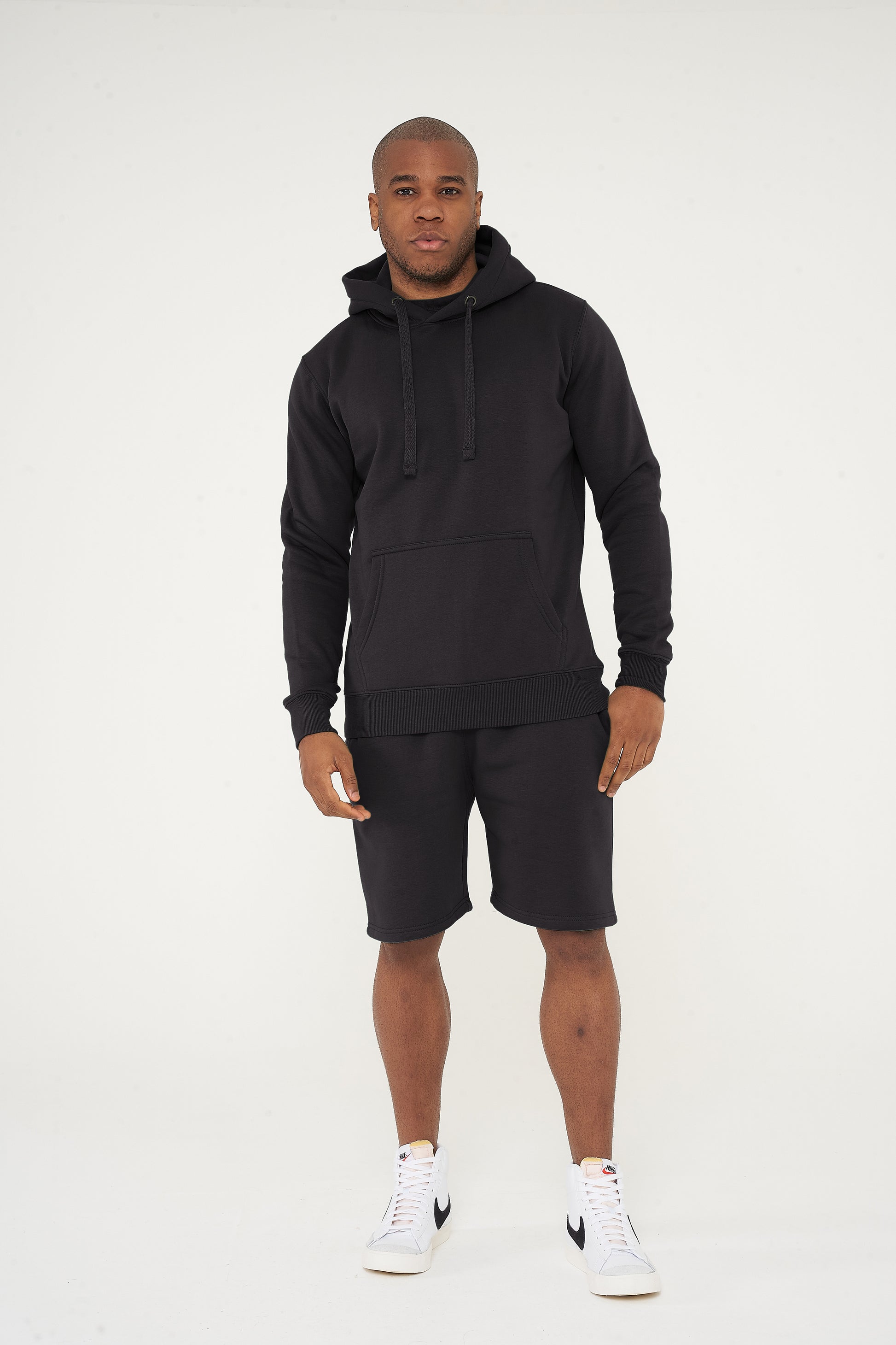 Male model front view wearing black 365 Regular Hoodie and matching shorts – regular fit, 365 Collection.