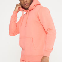 Male model side angle adjusting hood of coral 365 Regular Hoodie and shorts – regular fit, 365 Collection. 