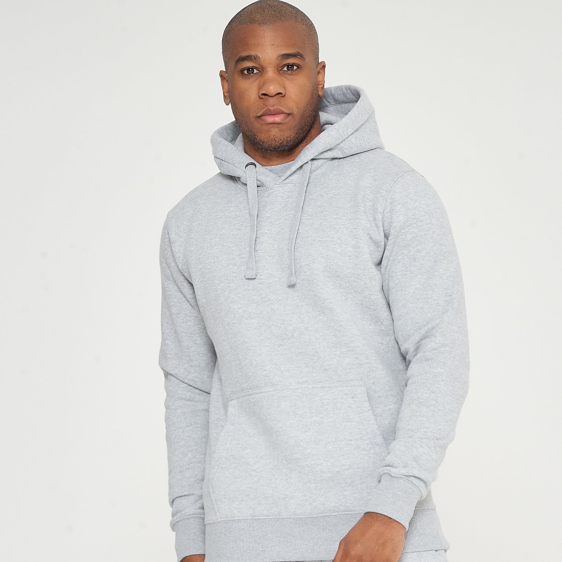 Full-body front view of a male model wearing a grey regular fit hoodie and matching shorts - 365 Collection.