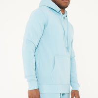 Side view of model in turquoise 365 Regular Hoodie – stylish men’s hoodie for daily wear.