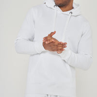 Model posing with arms clasped, wearing a men’s white regular-fit hoodie – 365 Collection.