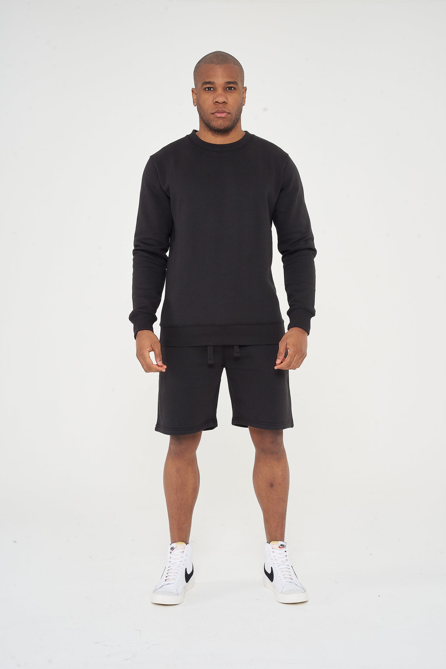 Male model front view wearing black 365 Regular Sweatshirt and matching shorts – regular fit, 365 Collection.
