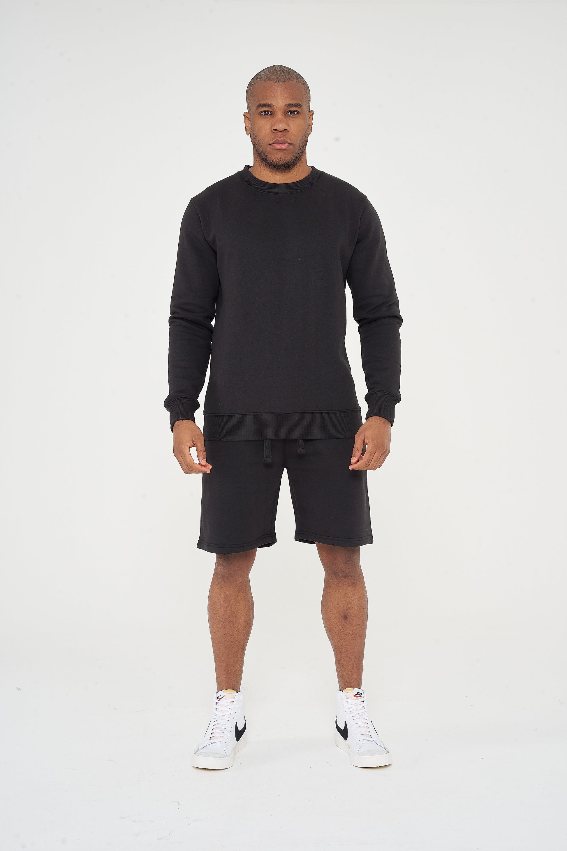 Male model front view wearing black 365 Regular Sweatshirt and matching shorts – regular fit, 365 Collection.