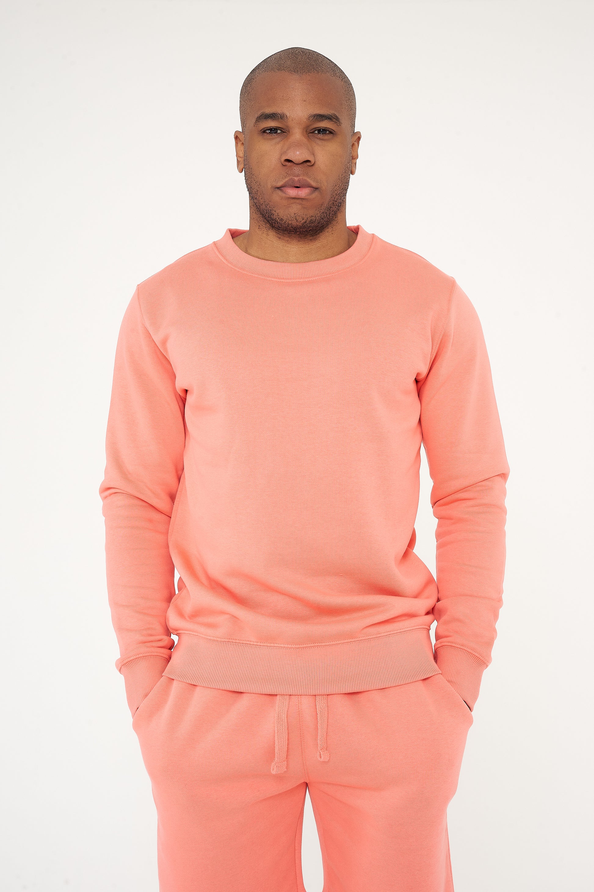 Male model front view wearing coral 365 Regular Sweatshirt and matching sweatpants – 365 Collection – regular fit.