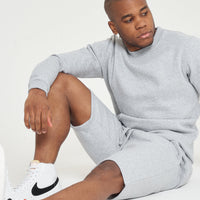 Model seated on the floor wearing a grey regular-fit sweatshirt - 365 Collection.