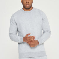 Model in grey regular-fit sweatshirt standing with fingers lightly gripping the other hand - 365 Collection.