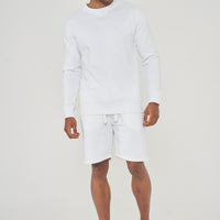 Three-quarter front view of male model in white oversized sweatshirt – 365 Collection.
