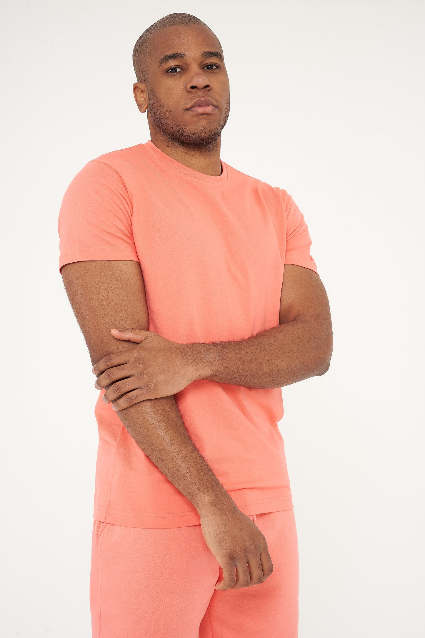 Male model with arms crossed wearing coral 365 Regular T-shirt and shorts – 365 Collection – regular fit. 