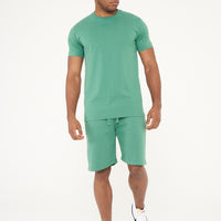 Side view of male model in green regular fit T-shirt and shorts, showing comfort and fit - 365 Collection.