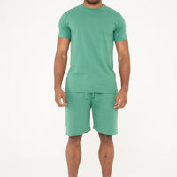 Full-body front view of a male model wearing a green regular fit T-shirt and matching shorts - 365 Collection.