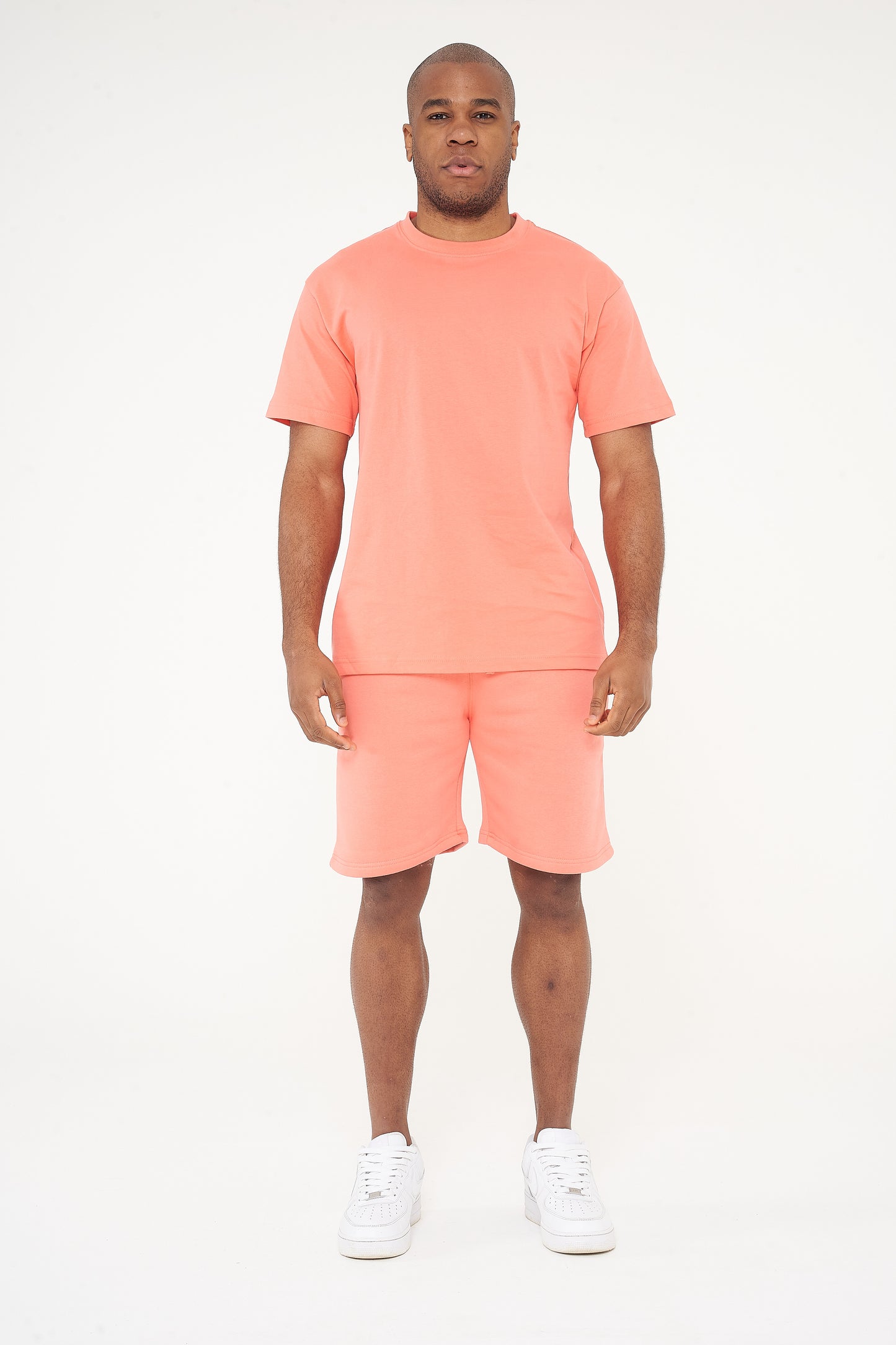 Male model side view wearing coral 365 fleece shorts and matching T-shirt – relaxed fit, 365 Collection. 