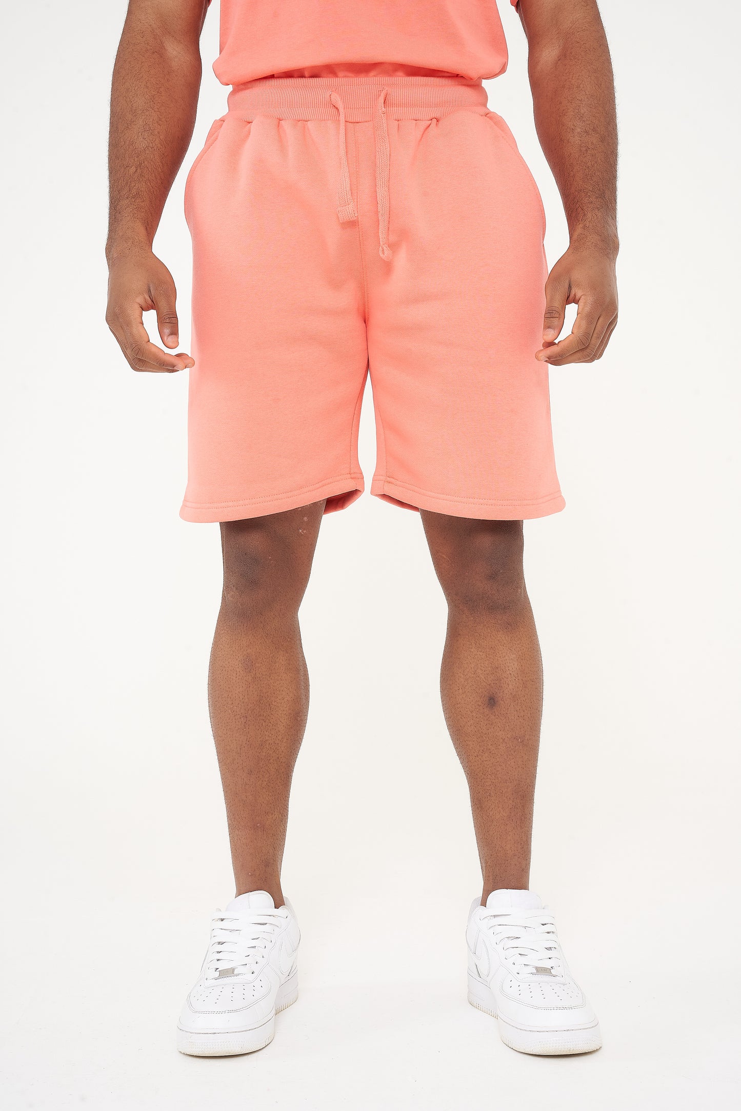Male model front view wearing coral 365 fleece shorts and matching T-shirt – relaxed fit, 365 Collection. 