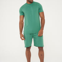 Side view of male model in green regular fit shorts and T-shirt - 365 Collection.