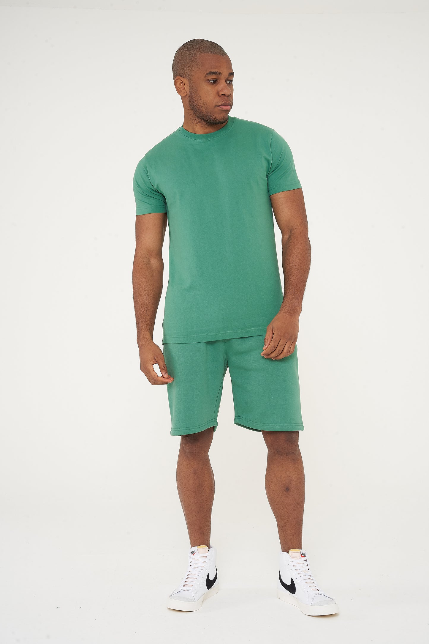 Side view of male model in green regular fit shorts and T-shirt - 365 Collection.