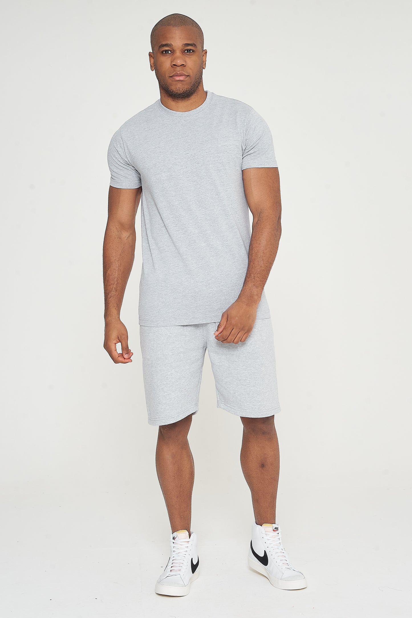 Model walking forward in grey regular-fit shorts and a matching T-shirt - 365 Collection.