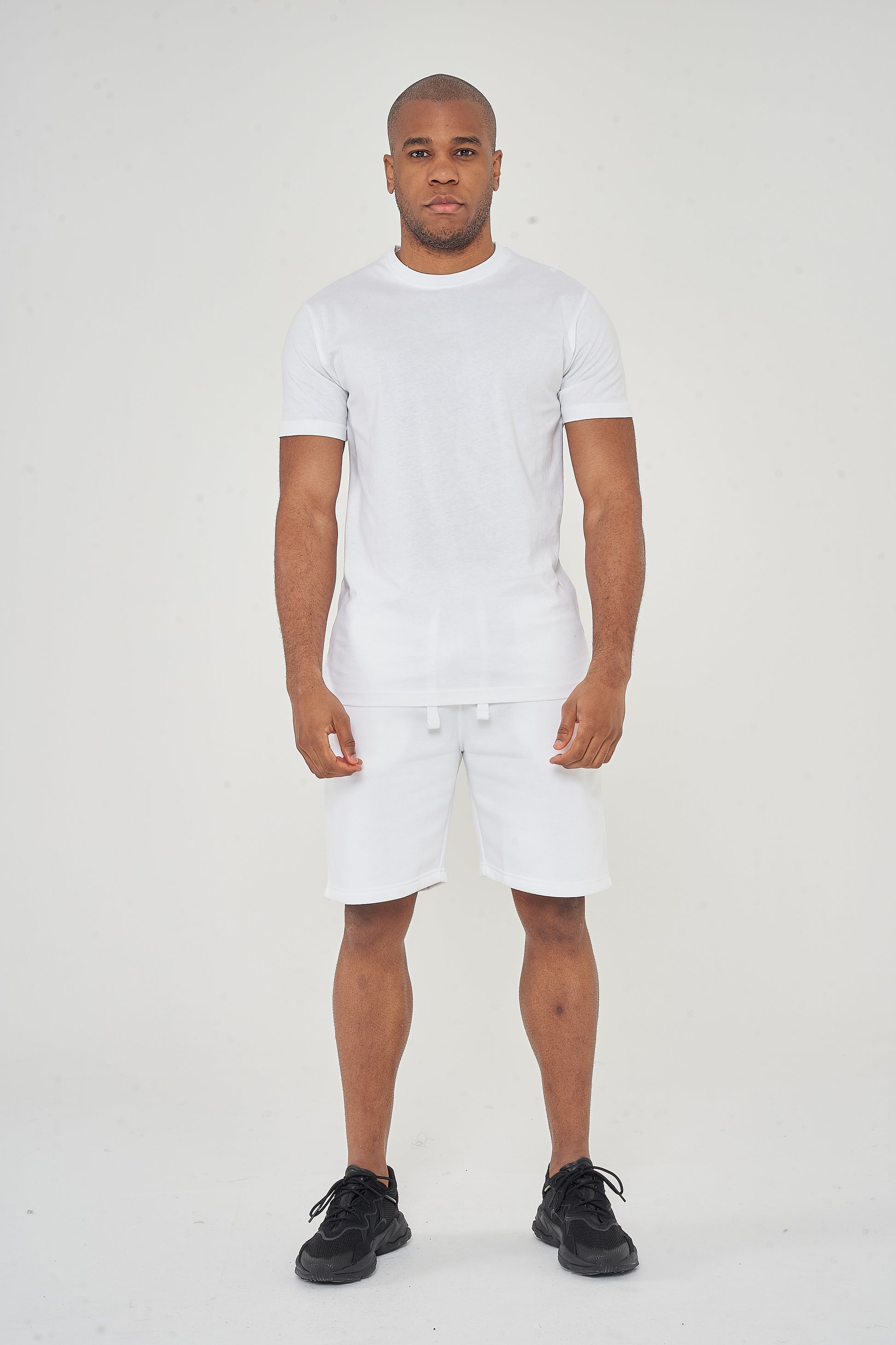 Front view of model wearing men's white regular-fit shorts, 365 Collection.