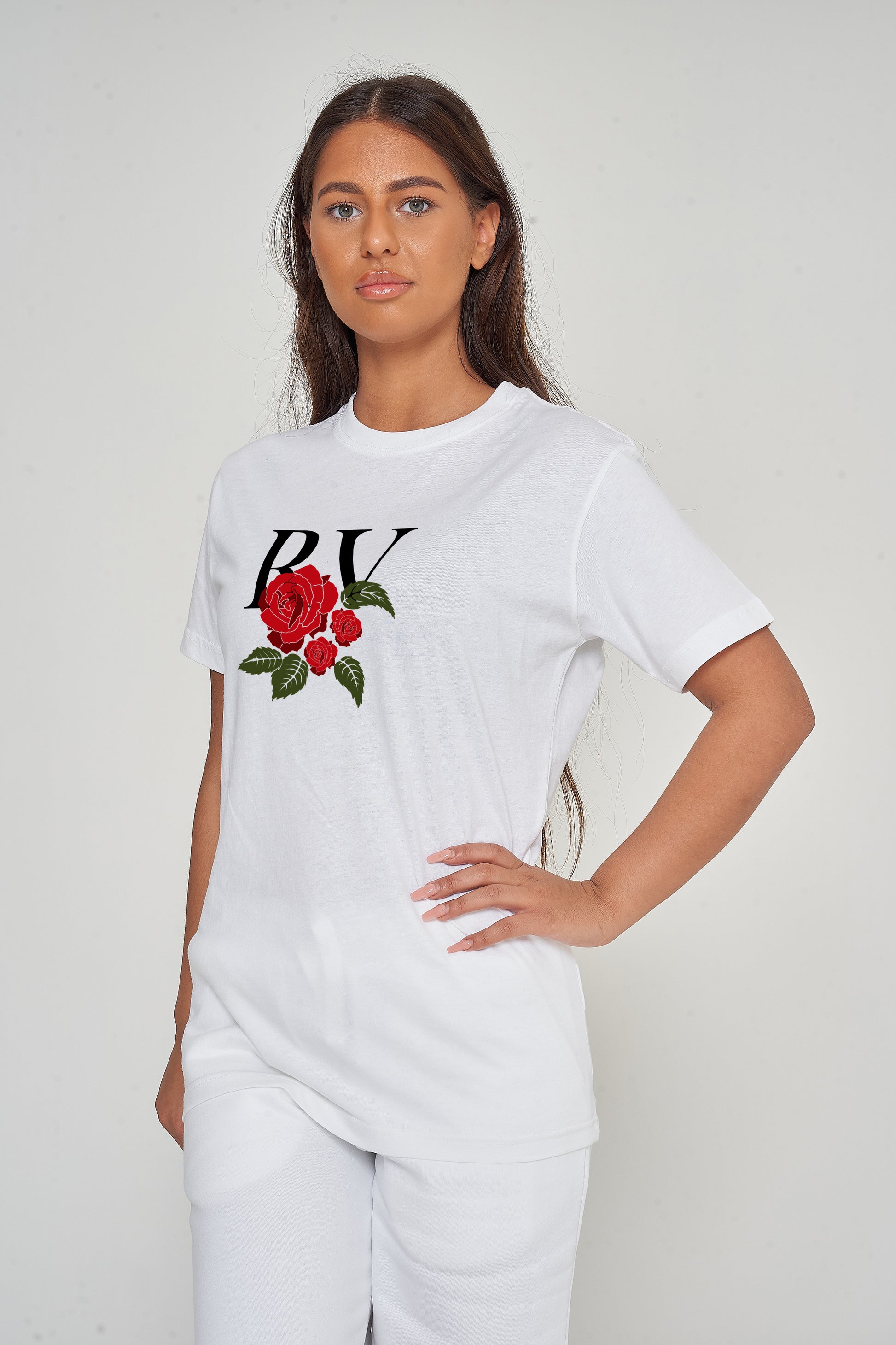 Woman wearing the white R &amp; V Rose Oversized T-Shirt styled with casual bottoms, highlighting the front rose print and comfortable, relaxed fit.