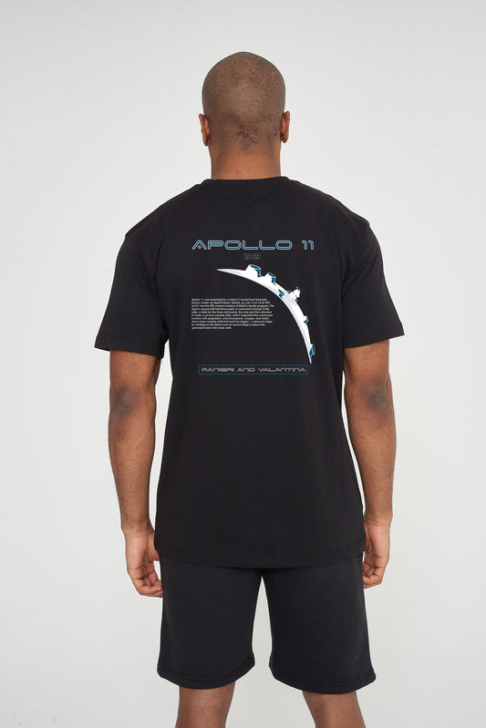 Male model rear view wearing black Apollo 11 Oversized T-shirt with Apollo mission graphic, paired with black shorts – oversized fit.