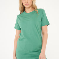 Woman wearing a green basic t-shirt with matching shorts, front view. 