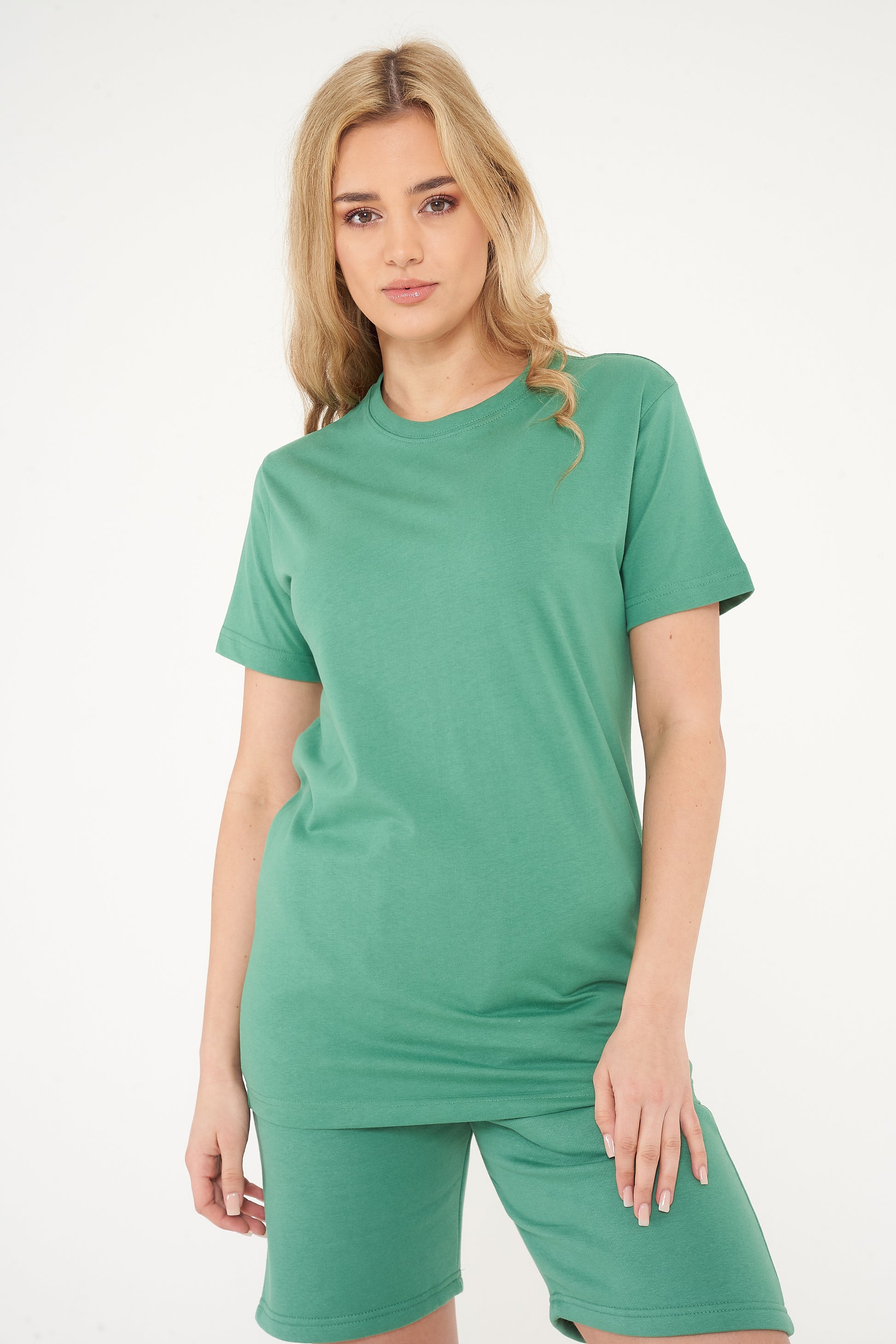 Woman wearing a green basic t-shirt with matching shorts, front view. 