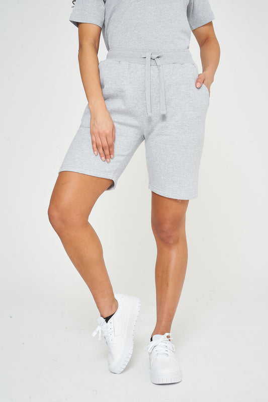 Woman wearing basic grey shorts with a matching grey t-shirt, front view. 