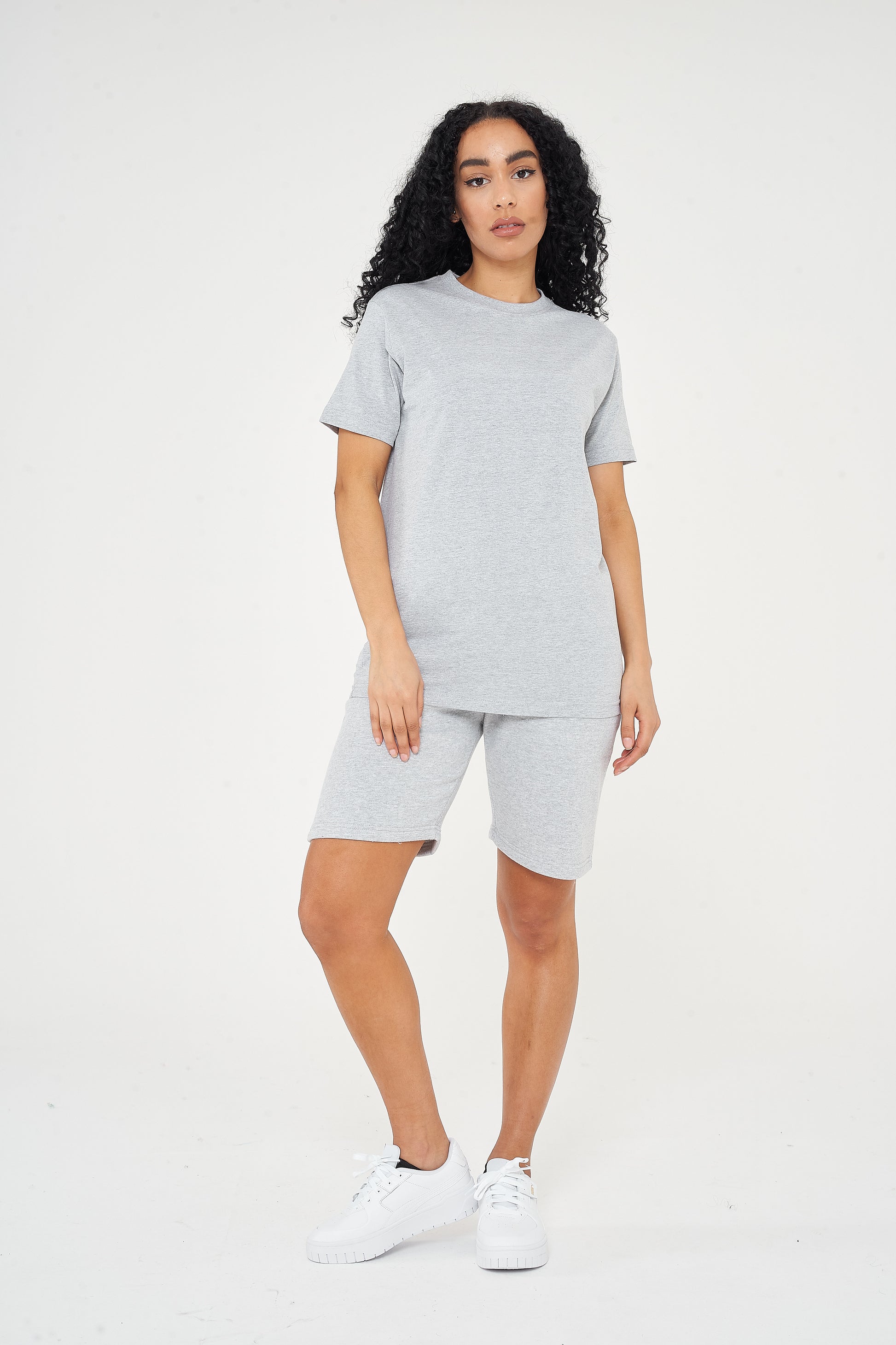 Woman wearing a basic grey t-shirt with matching shorts, front view. 