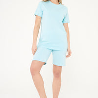 Woman wearing a turquoise basic t-shirt with matching shorts, front view.