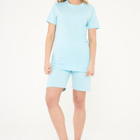 Woman modeling a turquoise basic cotton t-shirt, side pose. 