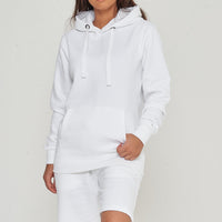 A woman wearing a basic white hoodie with casual shorts, front-facing. 