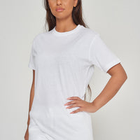Woman modeling a basic white cotton t-shirt, side pose in relaxed style.