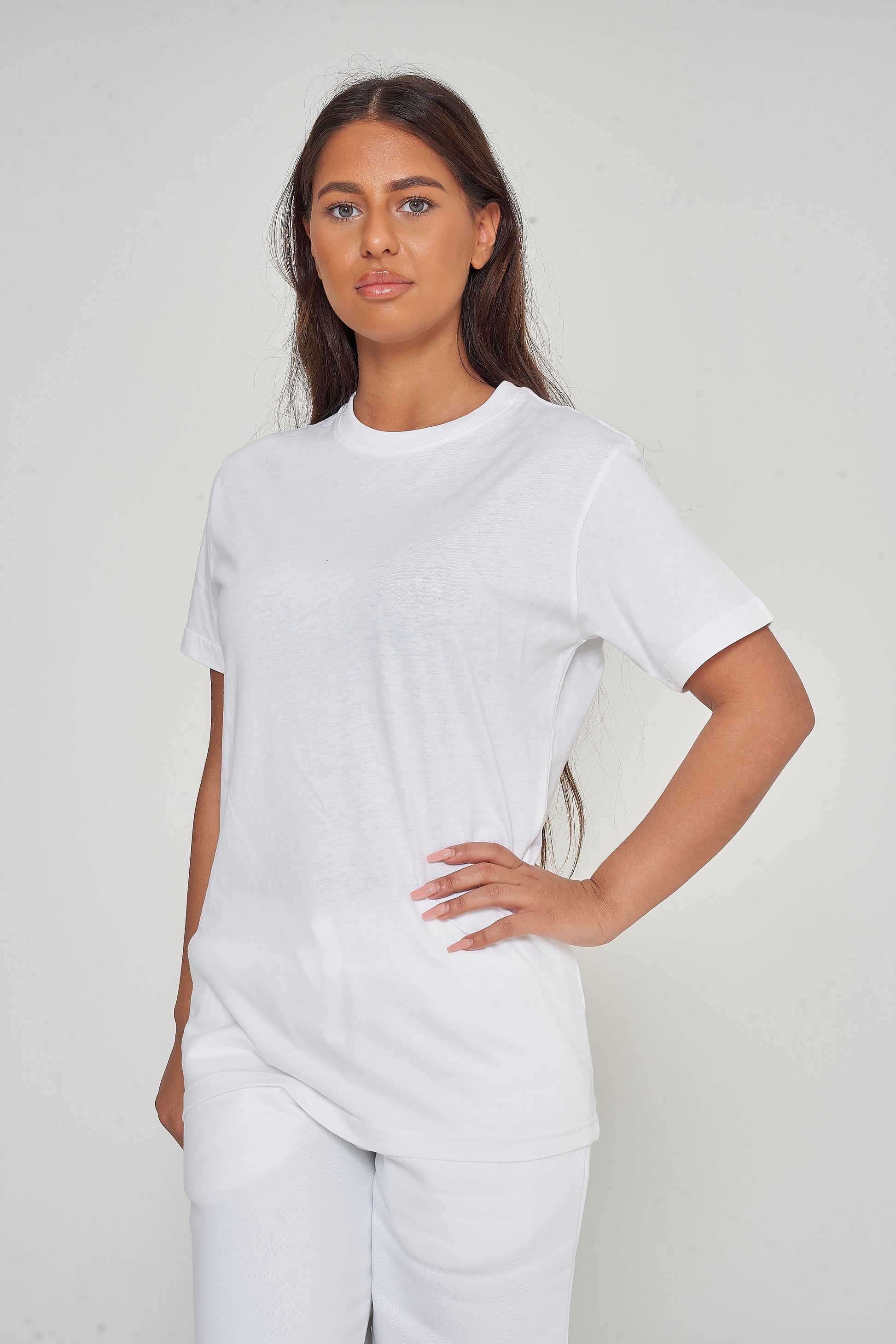 Woman modeling a basic white cotton t-shirt, side pose in relaxed style.