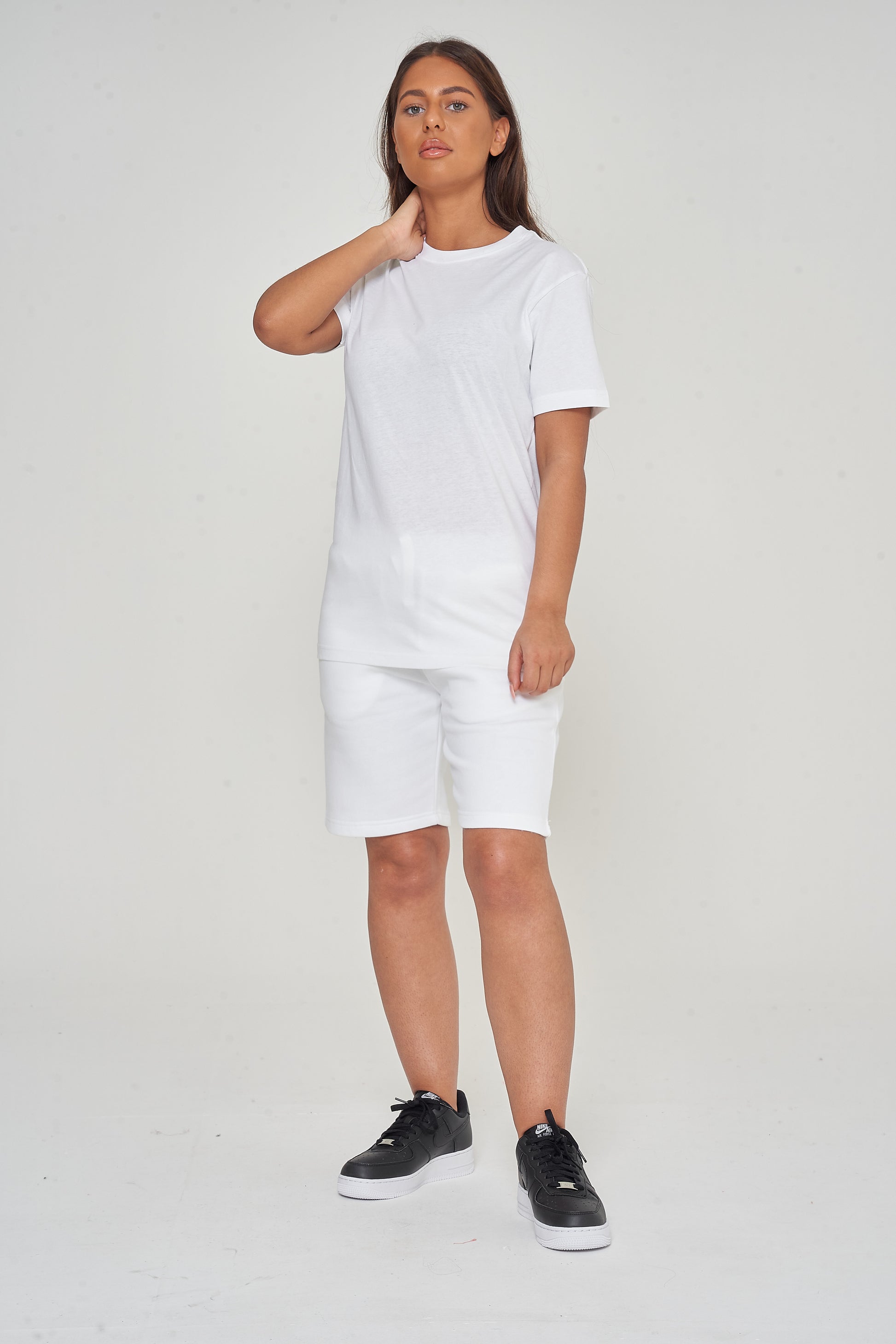 Woman wearing basic white t-shirt with casual shorts, front view.