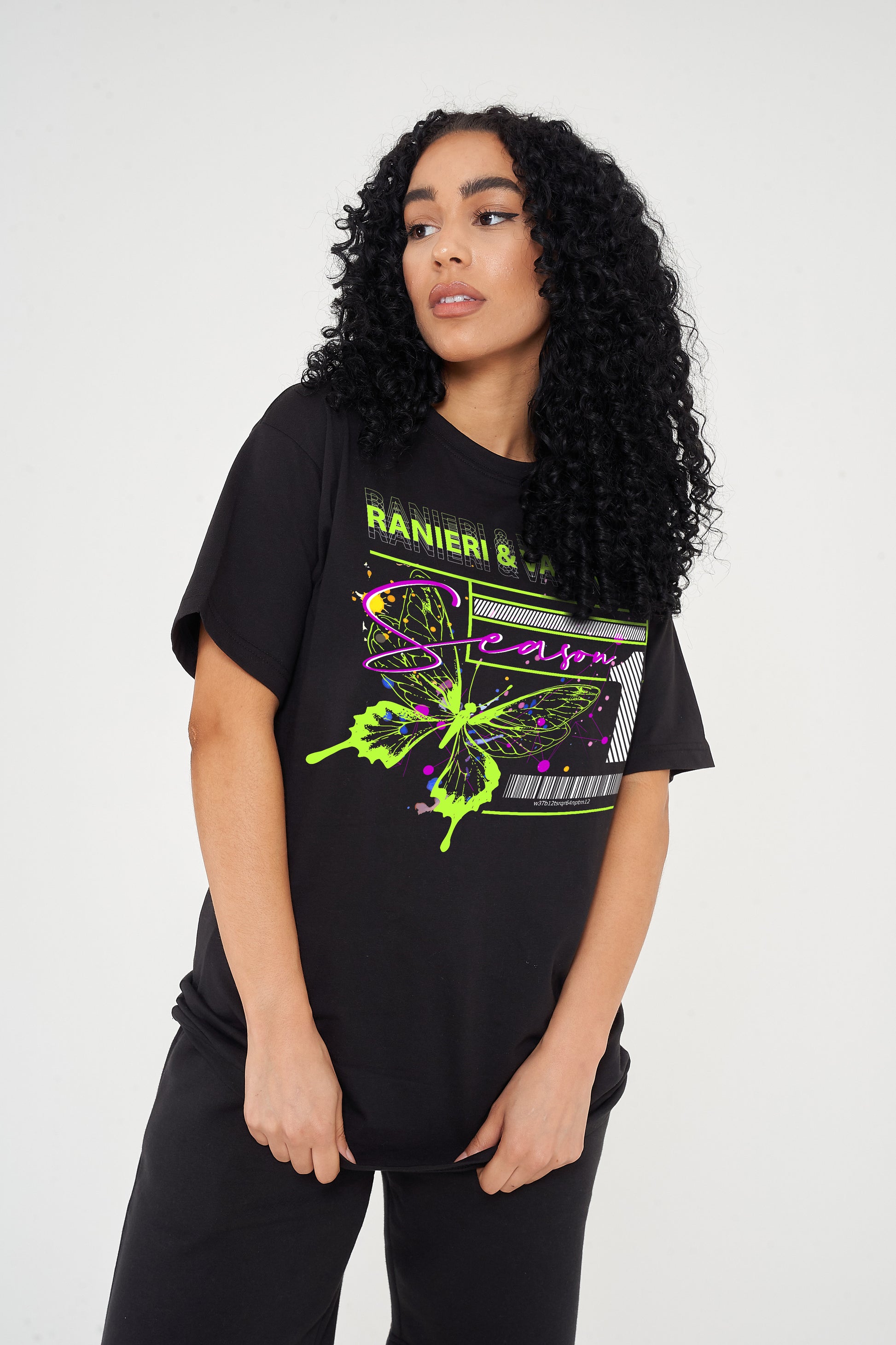 A woman wearing an oversized green Butterfly Season One graphic t-shirt with casual styling.